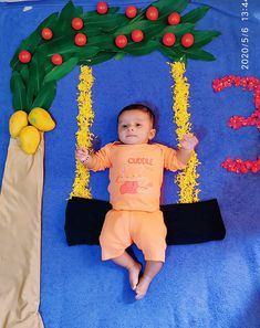 a baby laying on the ground next to some decorations