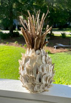 a pineapple sitting on top of a white table in front of a green field