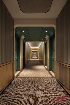 an empty hallway with green walls and brown carpeting on both sides, leading to another room