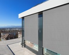 a large window on the side of a building overlooking a cityscape with mountains in the background