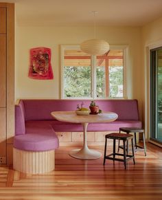 a table and bench in a room with wooden floors