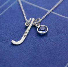 a close up of a necklace on a blue surface with an elephant charm hanging from it's side