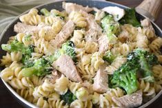 a pan filled with pasta and meat covered in broccoli