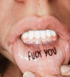 a close up of a person with writing on their tongue and the words flick you written on her lip