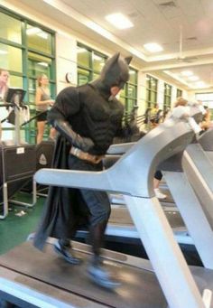 a man dressed as batman running on a treadmill