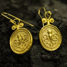 Ancient Octopus Gold Signet Earrings | 24K Gold Plated 925 Sterling Silver | Greek Art Kraken Earrings | Christmas Gift by Pellada Ancient Art Earrings made 24k gold plated Handcrafted Hanmade Earrings Metal : 925 Sterling Silver Plated : 24K Gold Coin : Reproduction Bronze Coin Coin Size : 23x20 mm Drop Length : 5 cm ( included hook) Earrings Weight : 8 grams **Custom Orders is Made** As pellada family, we will be happy to help you if you contact us with the photo and dimensions of the design y Gold Byzantine Handmade Earrings, Handmade Gold Byzantine Earrings, Handmade Byzantine Gold Earrings, Yellow Gold Byzantine Earrings Gift, Pierced Byzantine Jewelry Gift, Symbolic Gold Earrings As A Gift, Handmade Symbolic Yellow Gold Earrings, Symbolic Gold Earrings For Gifts, Ceremonial Gold Sterling Silver Earrings