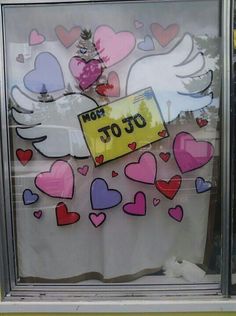 a window that has some stickers on it and hearts in the glass behind it