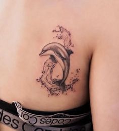 a woman with a dolphin tattoo on her stomach