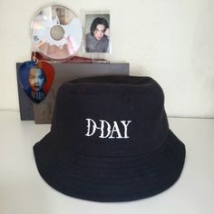 a black hat with the word d - day on it next to cd's