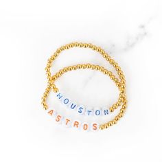 Cheer on our beloved Astros in style! Look like a home run on game-day in our Houston Astros team spirit bracelet set! Stainless steel beads are waterproof and will not tarnish. Stretch bracelets fit women and girls of all sizes and ages! White Team Spirit Bracelets For Game Day, Team Spirit Letter Beads Bracelets For Gift, Team Spirit Letter Beads Bracelets As Gift, Team Spirit Personalized Bracelets For Game Day, Game Day Bracelets With Letter And Round Beads, Team Spirit Round Beads Jewelry For Game Day, Personalized Beaded Bracelets For Team Events, Sporty Beaded Bracelets With Letter Beads For Team Events, Sporty Jewelry For Baseball Season Game Day