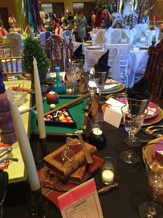 the table is set for an event with place settings, candles and other items on it