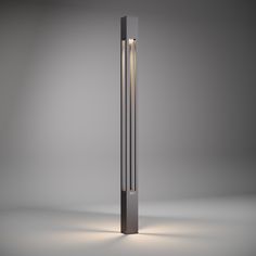 a tall metal pole with a light on it's side in the middle of an empty room