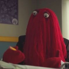 a woman with long red hair sitting at a desk