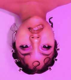 a woman is upside down in the bathtub with her hair blowing back and eyes closed