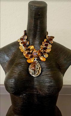 Here is a smaller version of my popular summer - fall shell statement necklaces pendant - chest pieces. Bronze abalone or mother of pearl teardrop shaped beads are given added drama with large bronze faceted crystals. The back of the necklace is finished with tiny golden citrine crystals and the necklace adjusts from 18-22". It features a cowry or cowrie shell pendant which measures 2.5" x 2". Finished with gold tone hardware, a fine bronze hook and a 4" bronze textured extender chain. Wearable Brown Beaded Shell-shaped Jewelry, Unique Handmade Shell-shaped Necklace, Unique Handmade Shell Necklaces, Brown Beaded Shell Jewelry, Handmade Mother Of Pearl Shell Pendant, Unique Mother Of Pearl Pendant Necklaces, Unique Mother Of Pearl Pendant Necklace, Unique Shell-shaped Shell Necklaces, Handmade Shell Necklace In Ocean Style