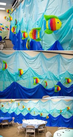 the wall is decorated with colorful fish and blue fabric, along with tables and chairs