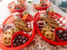 two red baskets filled with food on top of a table