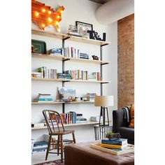 a living room filled with furniture and bookshelves next to a wall mounted book shelf