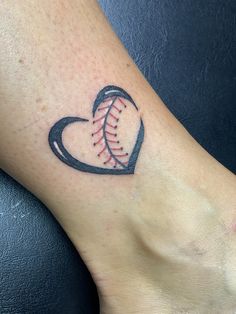 a heart shaped baseball tattoo on the foot with a ball in it's center