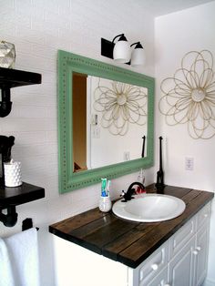 a bathroom with a sink, mirror and towel rack on the wall next to it