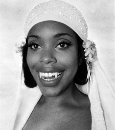 a black and white photo of a woman wearing a veil