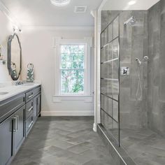 a large bathroom with two sinks and a walk - in shower next to a window