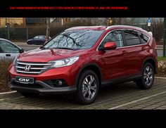 a red honda cr - v is parked on the side of the road