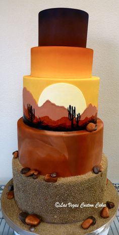 a three tiered cake with desert scenes on it