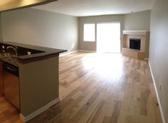 an empty kitchen and living room with wood floors