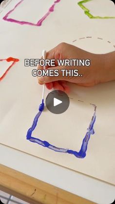 someone is writing something on paper with blue paint