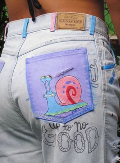 the back of someone's jeans with an image of a snail painted on it