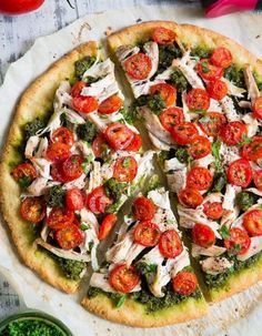 a pizza with tomatoes, broccoli and chicken on it sitting on a table