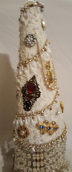 a white and gold christmas tree made out of pearls, jewels and other jewelry items