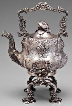 an antique silver teapot with ornate decoration