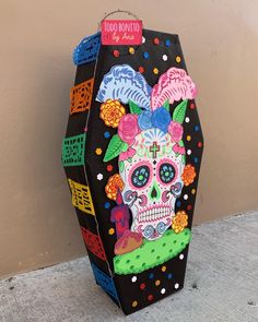 a paper bag decorated with sugar skulls and flowers