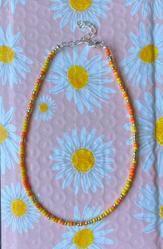 This is a sunrise colored necklace worn around the neck Festival Orange Large Beaded Necklaces, Orange Large Beaded Necklace For Festivals, Festival Orange Large Beads Necklace, Festival Orange Large Beaded Necklace, Yellow Beaded Necklaces For Beach, Tiny Yellow Beads For Summer, Orange Tiny Beads Necklace For Gift, Orange Necklaces With Tiny Beads For Gift, Yellow Round Beads Jewelry For Beach