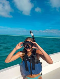 a woman in a life jacket and goggles on a boat