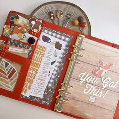 an open planner book sitting on top of a wooden table next to a piece of wood