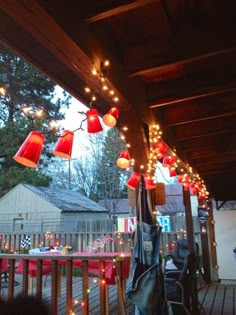 red lanterns are hanging from the roof of a house with lights on it's sides