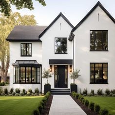 a large white house with black trim and windows on the front door is shown in this rendering