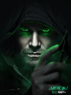 a man with green eyes and a hoodie holding a cell phone in his hand