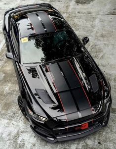 a black sports car with red stripes parked in the snow