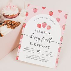 a pink box filled with cupcakes and muffins on top of a table