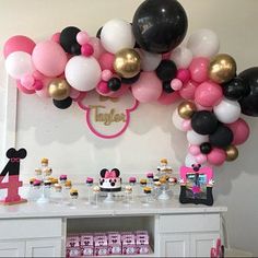 a table topped with balloons and minnie mouse decorations