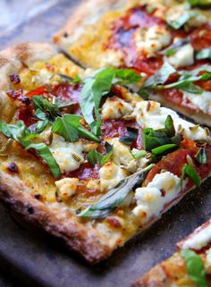 two slices of pizza with basil and mozzarella toppings on a baking sheet