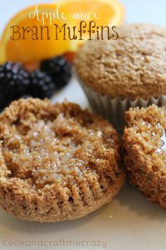 three muffins are sitting on a plate next to some berries and an orange