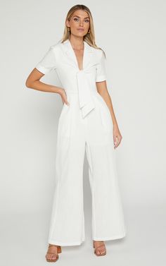 Get ready to turn heads in the Naples Wrap Front Jumpsuit In White! This wide leg jumpsuit is perfect for those casual summer days or dress it up with some heels for a night out. Made from 100% cotton, this jumpsuit is lightweight and breathable, keeping you cool and comfortable all day long. With its flattering wrap front detail and short sleeves, this jumpsuit will accentuate your figure in all the right places. So go ahead, embrace your playful side and add this flirty white jumpsuit to your Solid Color Summer Jumpsuits And Rompers For Day Out, Summer Loungewear Jumpsuits And Rompers Overall, Summer Cotton Jumpsuits And Rompers For Vacation, White Wide Leg Jumpsuits And Rompers For Beach, Summer Short Sleeve Relaxed Fit Jumpsuits And Rompers, Spring Vacation Cotton Jumpsuits And Rompers, Chic Cotton Summer Jumpsuits And Rompers, Wide Leg Jumpsuit For Beach, Chic Cotton Jumpsuits And Rompers For Summer