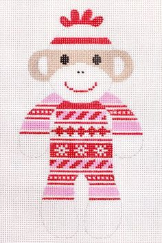 a cross stitch monkey with a red hat and sweater on it's head, standing in