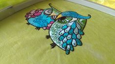 an image of a colorful bird on green fabric