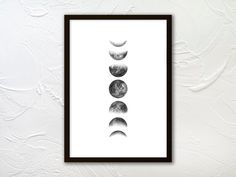 three phases of the moon in black and white framed on a wall with paint splatches